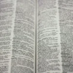 Open dictionary laid flat showing two pages with dense small print.